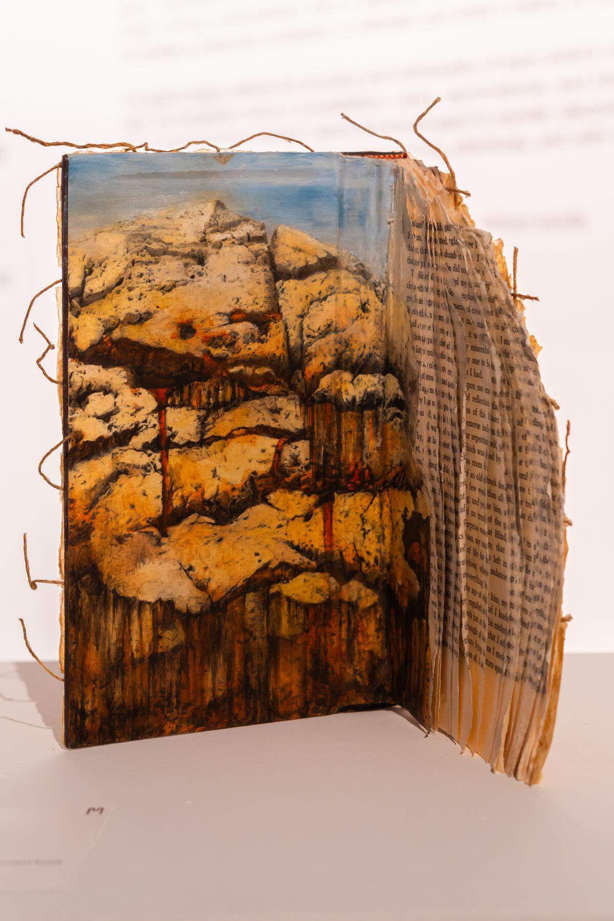 ‘The Unfolding’, 2024 de Mary Larsen. Acrílico, papel, y cera sobre un libro deconstruido, 9 x 9 x 7 pulgadas.
