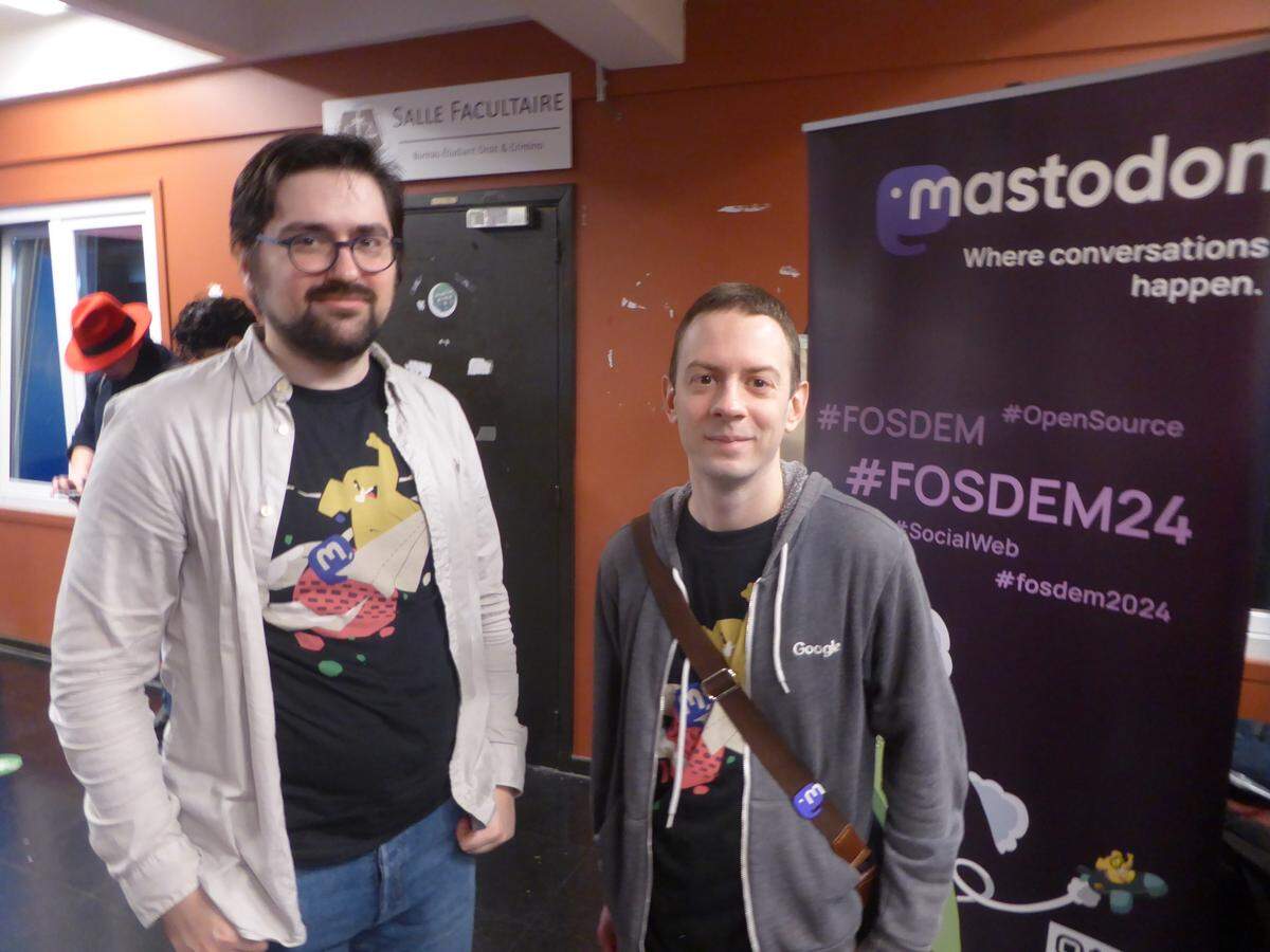 Eugen Rochko con un desarrollador de Mastodon en el stand de Mastodon en FOSDEM 2024.