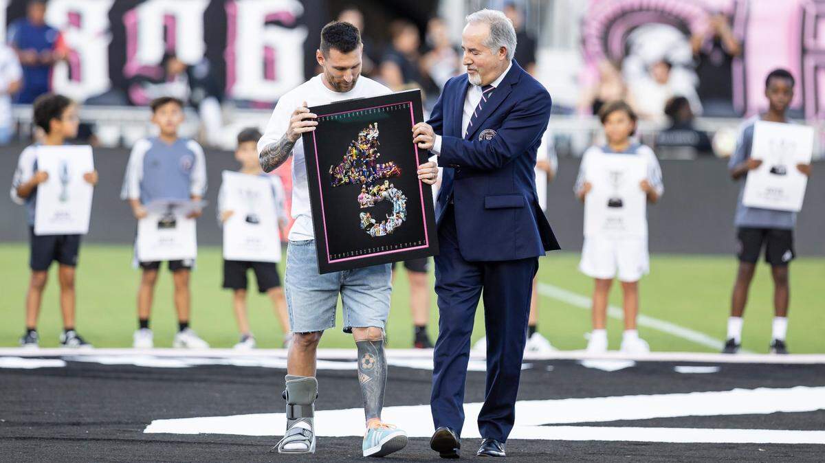 El delantero del Inter Miami Lionel Messi recibe un reconocimiento por los 45 títulos logrados en su carrera de manos de uno de los propietarios del equipo, Jorge Mas, en la ceremonia celebrada el 20 de julio de 2024 en el Chase Stadium en Fort Lauderdale, Florida.