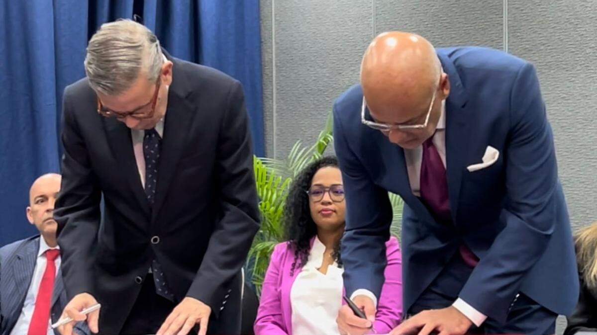 Gerardo Blyde, representante de la delegación de la Plataforma Unitaria de la Oposición en las negaciones (izq.), y Jorge Rodríguez, jefe de delegación del régimen de Nicolás Maduro, firman un acuerdo parcial el 17 de octubre en Barbados.