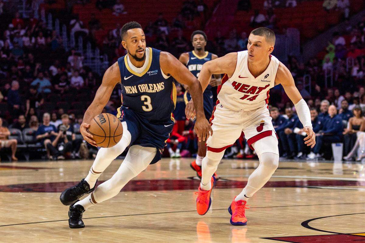 El jugador de los Pelicans CJ McCollum (izq.) entra al aro ante la marca de Tyler Herro, del Heat, en el partido celebrado el 13 de octubre de 2024 en Miami.