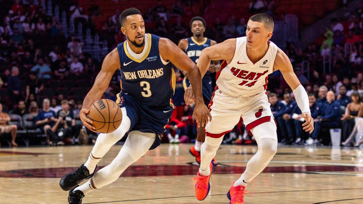 El jugador de los Pelicans CJ McCollum (izq.) entra al aro ante la marca de Tyler Herro, del Heat, en el partido celebrado el 13 de octubre de 2024 en Miami.