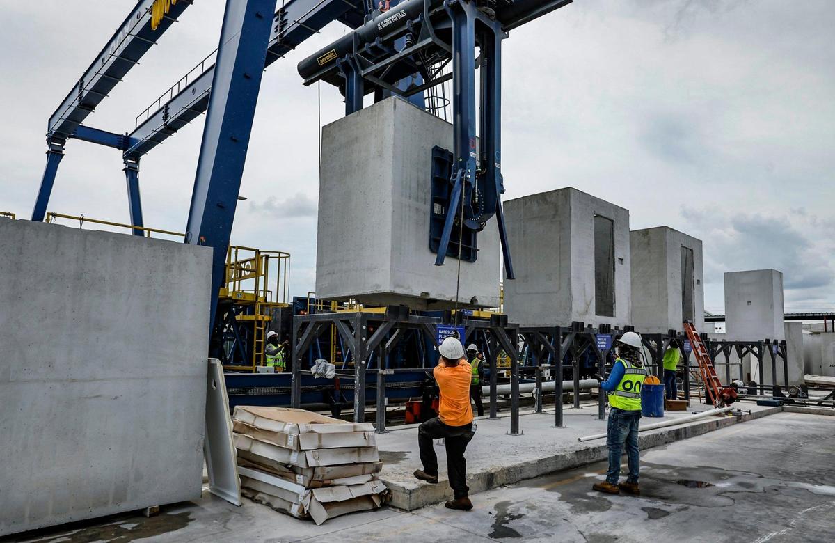 Trabajadores de la fábrica ONX Homes trasladan los baños prefabricados que luego se instalan en las urbanizaciones de casas nuevas que construye la compañía en el sur de la Florida, según se mostró en una visita para la prensa el 1 de junio.
