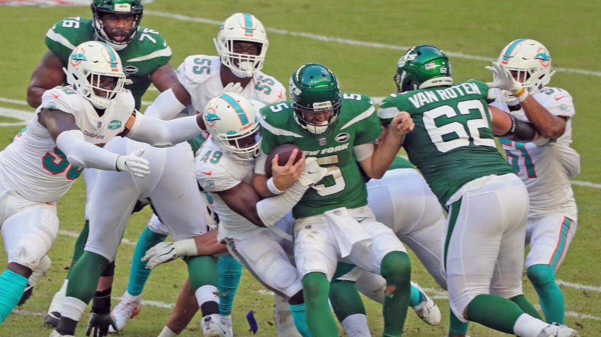 El linebacker de los Dolohins Sam Eguavoen (49) derriba al quarterback de los Jets de New york Joe Flacco (5) , en la primera mitad del partido celebrado el 18 de octubre de 2020 en el Hard Rock Stadium en Miami Gardens, Florida.