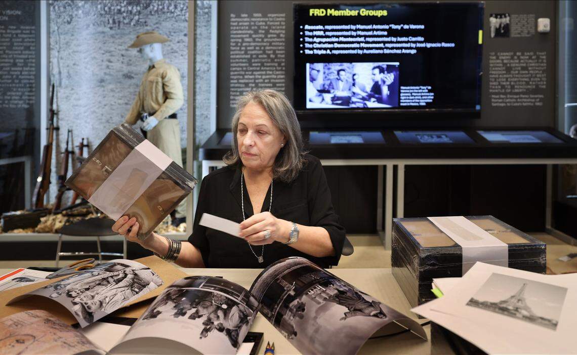The curator of the new Bay of Pigs Brigade 2506 Museum, Carmen Valdivia, sorts through photographs and other material to prepare for the site’s opening.