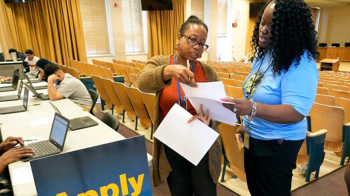 Fola Parrett (izq.) y LaQuita Hoskin, de las Escuelas Públicas de Milwaukee, en Wisconsin, revisan planillas de solicitud de empleos, el 18 de septiembre de 2024.