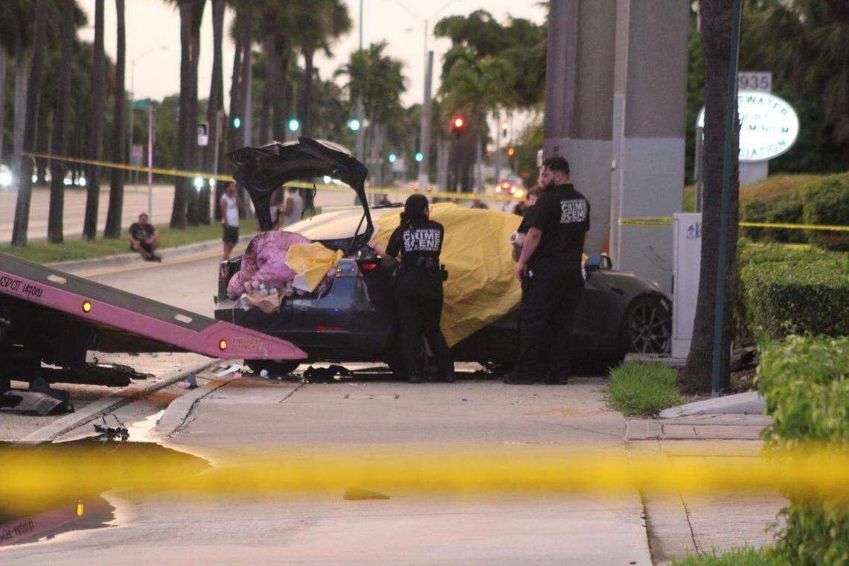 Investigadores de la policía cerca de un sedán Tesla que se estrelló en North Miami Beach el miércoles 1ro. de octubre de 2025. La conductora que murió fue identificada por la sinagoga a la que asistía como Julie Eibinder, de 24 años.