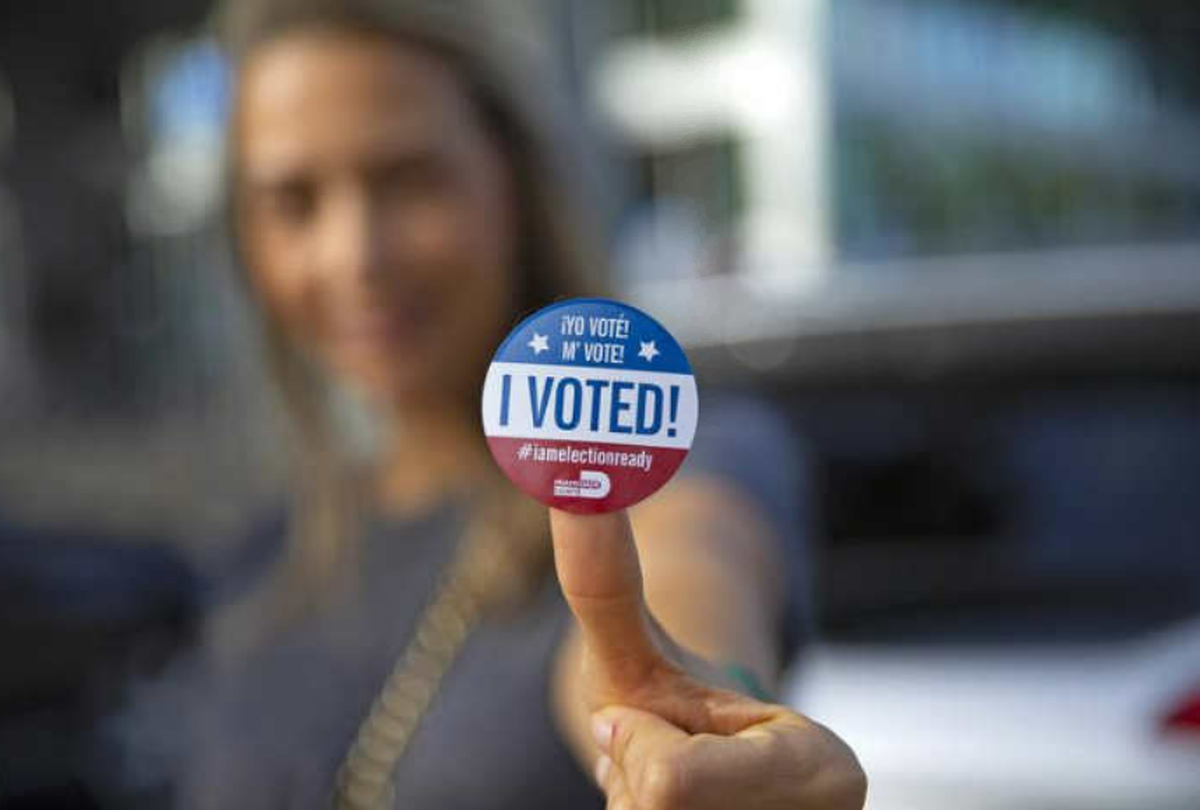 Sucel Peleg posa con su calcomanía después de emitir su voto durante la votación anticipada para las elecciones generales en Northeast Dade Aventura Branch Library, el miércoles 28 de octubre de 2020 en Aventura, Florida.