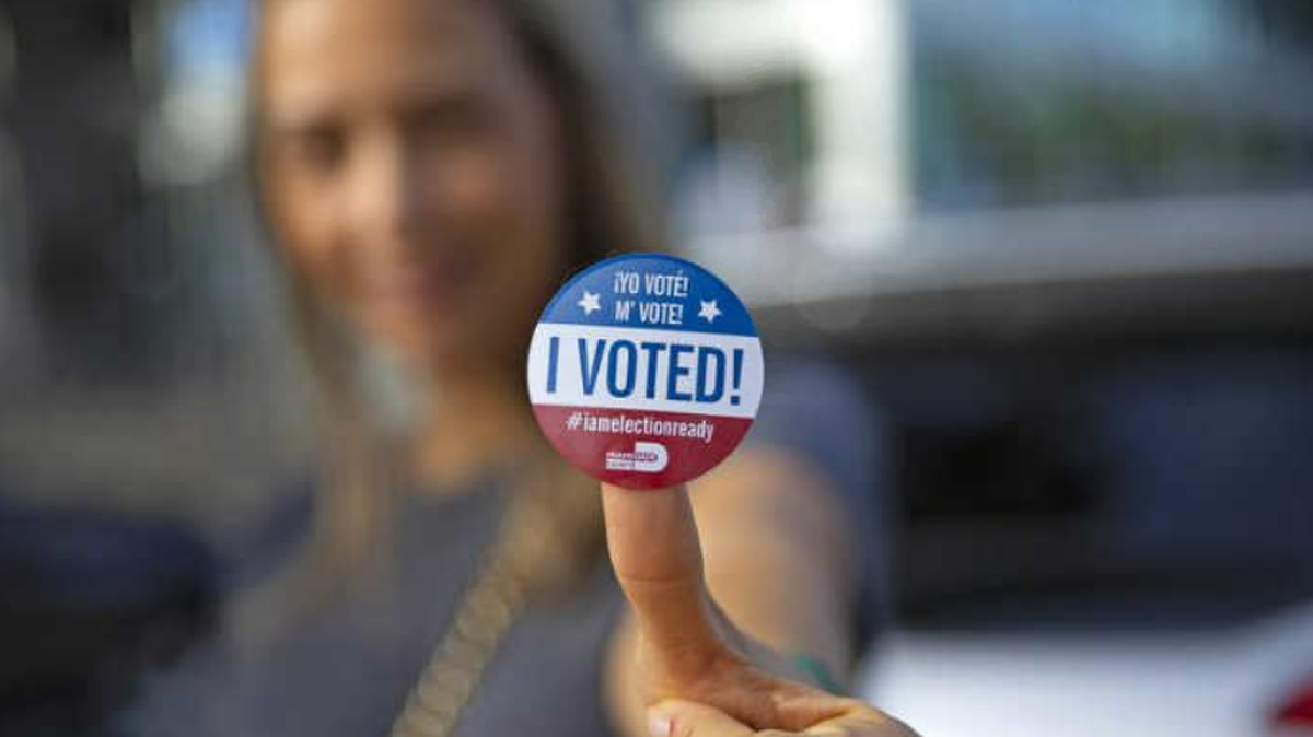 Sucel Peleg posa con su calcomanía después de emitir su voto durante la votación anticipada para las elecciones generales en Northeast Dade Aventura Branch Library, el miércoles 28 de octubre de 2020 en Aventura, Florida.