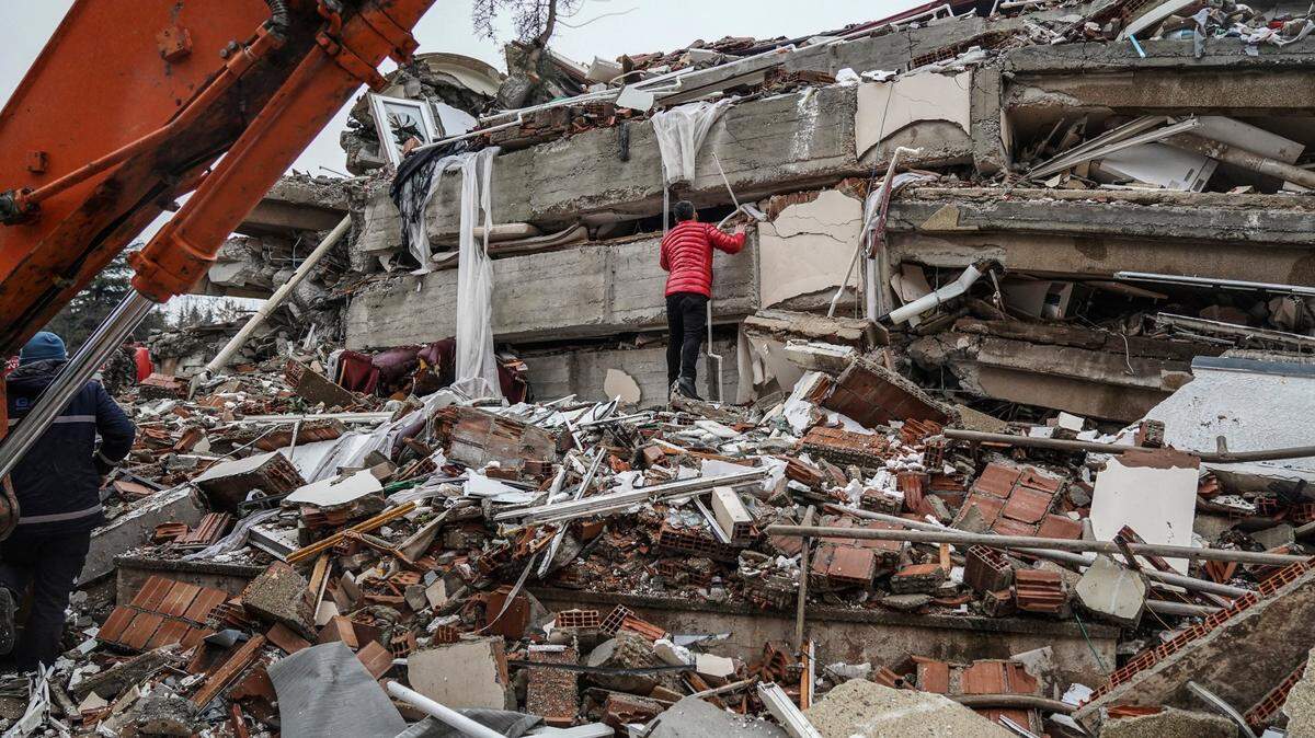 Un hombre busca personas entre los escombros de un edificio destruido en Gaziantep, Turquía, el lunes 6 de febrero de 2023.