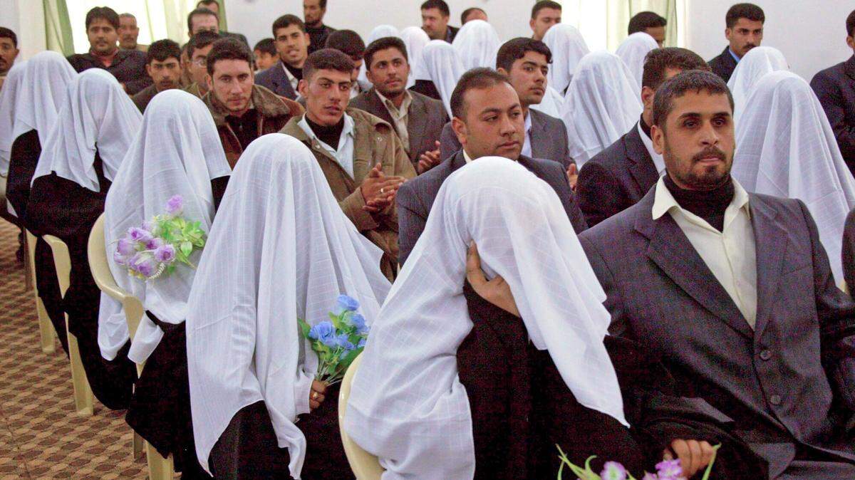 Varias parejas contraen matrimonio en una boda masiva organizada por el Consejo Supremo de la Revolución Islámica en Nayaf, Irak.