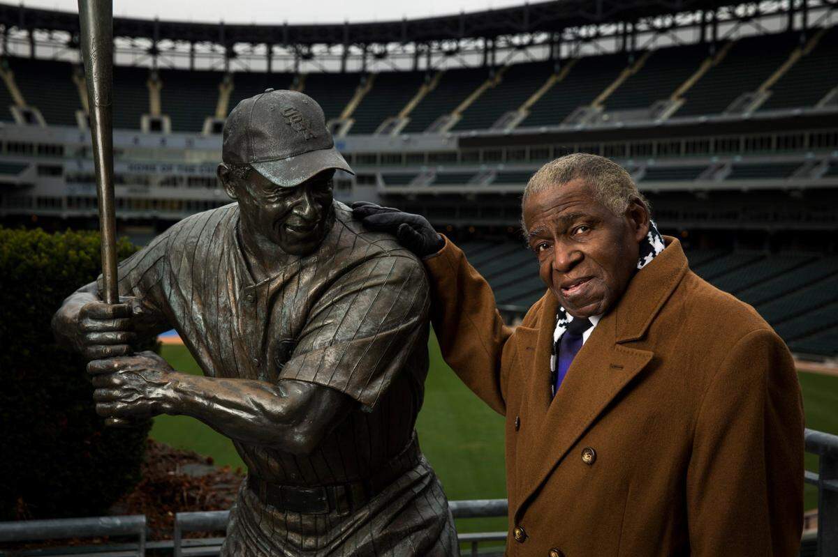 Foto de archivo. El exjugador de los Medias Blancas Orestes Miñoso posa junto a su estatua en el U.S. Cellular Field en Chicago, Illinois, el viernes 14 de noviembre de 2014.