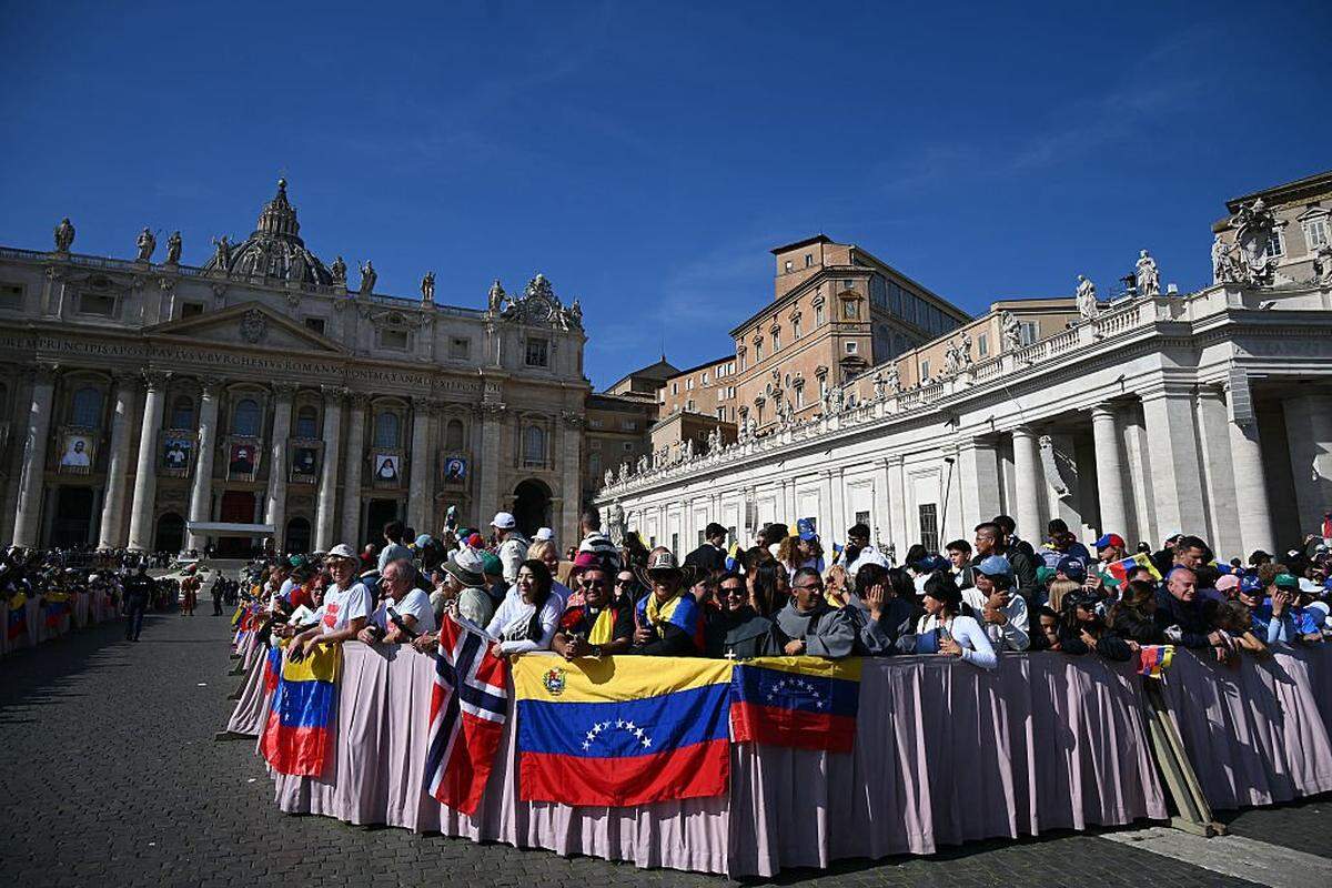 Faithful stand with Venezuela's flags as they wait for Pope Leo XIV tour after a mass for the canonization of seven new Saints at St Peter's square in The Vatican, on October 19, 2025. (Photo by Filippo MONTEFORTE / AFP) (Photo by FILIPPO MONTEFORTE/AFP via Getty Images)