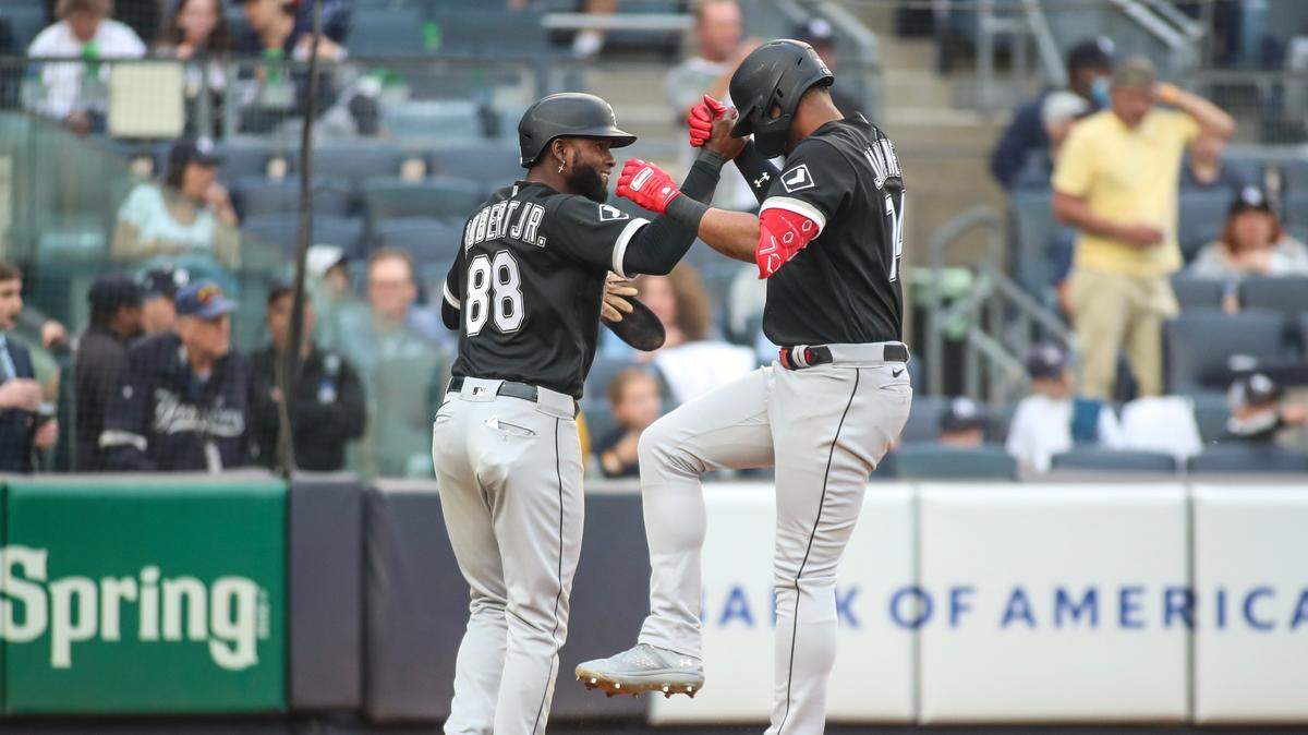El jardinero de los Medias Blancas Luis Robert (izq.) felicita a su compañero de equipo Eloy Jiménez tras pegar un jonrón en el séptimo inning del partido ante los Yankees, celebrado el 8 de junio de 2023 en Nueva York.