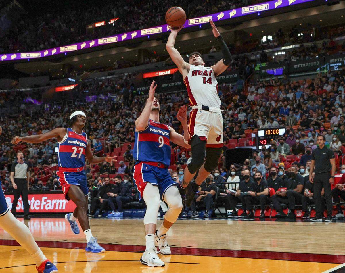 El jugador del Heat Tyler Herro (14) entra al aro ante la marca de Deni Avdija, de los Wizards de Washington, en el partido celebrado el 28 de diciembre de 2021 en Miami.