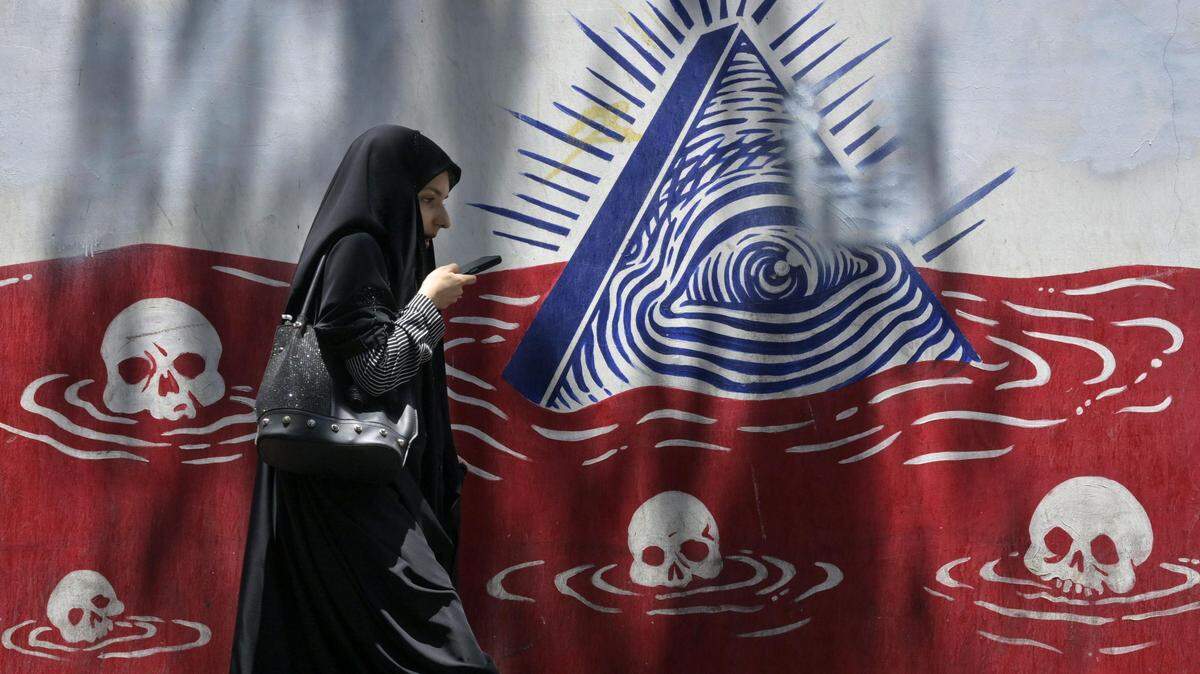 Foto de archivo de una mujer camina frente a un mural crítico de Estados Unidos, en Teherán, Irán, el 23 de julio de 2025.