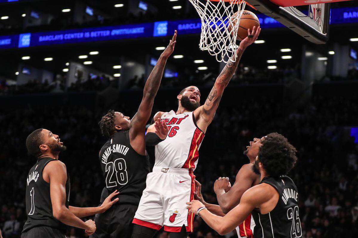 El jugador del Heat de Miami Caleb Martin (16) entra al aro ante la marca de Dorian Finney-Smith, de los Nets, en el partido celebrado el 15 de enero de 2024 en Brooklyn, Nueva York.