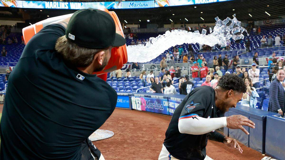 El jardinero de los Marlins Dane Myers recibe un baño de agua tras pegar el batazo que dejó al campo a los Piratas de Pittsburgh en el inning 13, en el partido celebrado el 29 de marzo de 2025 en Miami.