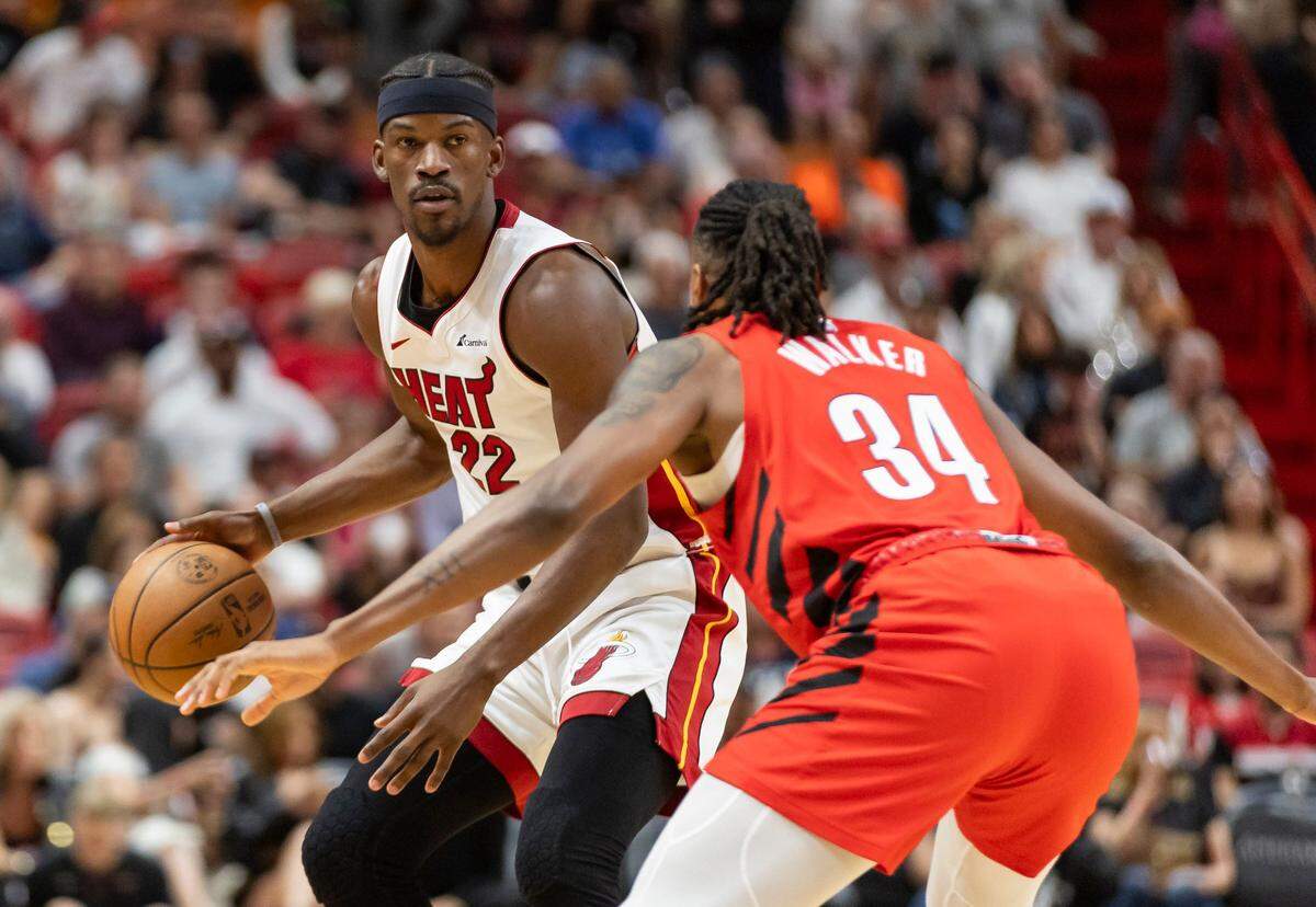 El jugador del Heat Jimmy Butler (izq.) trata de pasar la marca de Jabari Walker, de los Trail Blazers de Portland, en el partido celebrado el 29 de marzo de 2024 en Miami.