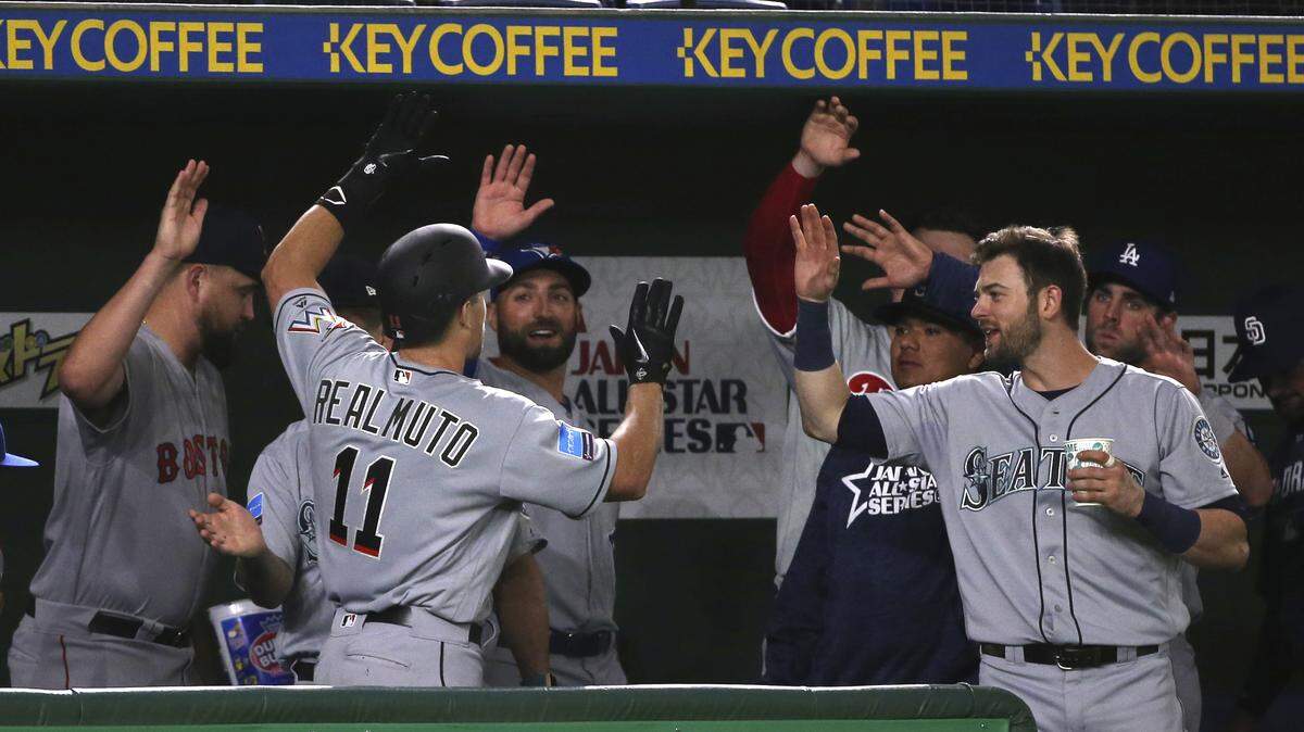 J.T. Realmuto (11) es felicitado por sus compañeros de equipo tras pegar un jonrón ante los Gigantes de Yomiuri, en un partido de exhibición de las estrellas de Grandes Ligas en Tokio, Japón, el 8 de noviembre de 2018.