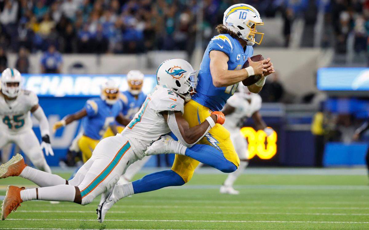 El safety de los Dolphins de Miami Eric Rowe derriba al quarterback de los Chargers Justin Herbert, en el partido celebrado el 11 de diciembre de 2022 en el SoFi Stadium en Inglewood, California.
