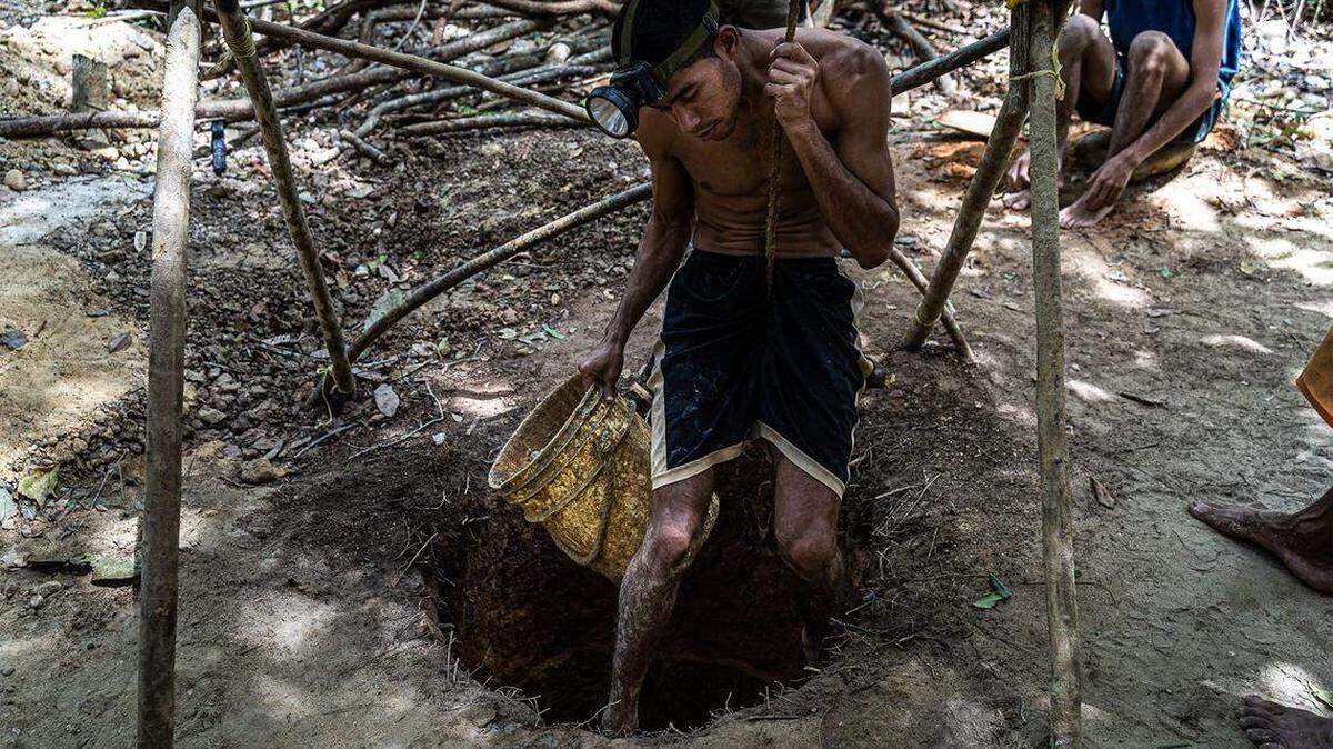 Con una cuerda, un minero se prepara para descender a la tierra en Tumeremo, Venezuela. El trabajo no solo es sucio y peligroso —debido, en parte, al uso de mercurio tóxico para separar el oro de la roca—, sino que también pone en peligro a las comunidades aledañas al envenenar los ríos y los peces que los habitan.