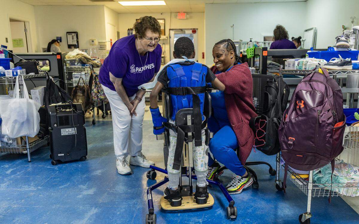 Kyle Smith (izq), directora ejecutiva y cofundadora de Patches, comparte con Shaniqua Garrod, asistente de enfermería certificada, mientras alimenta a uno de los pacientes de la organización sin fines de lucro, en Florida City.