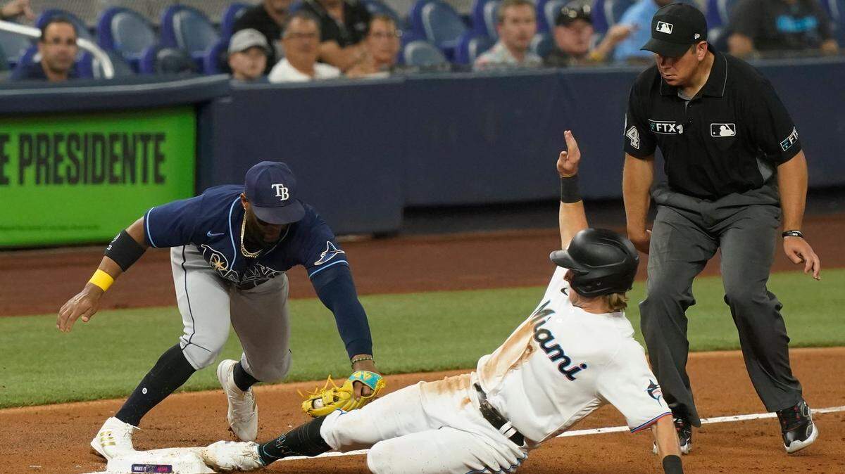 El tercera base de los Rays de Tampa Bay Yandy Díaz pone out a Luke Williams, de los Marlins, en el tercer inning del partido celebrado el 30 de agosto de 2022 en Miami.