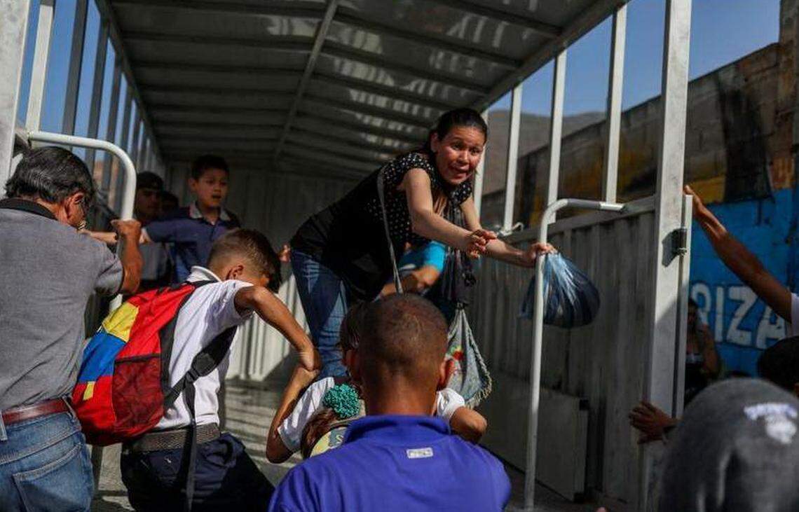 Usuarios tratan de subir a una "perrera" el 8 de junio de 2018, en Caracas (Venezuela). Los venezolanos han visto en los últimos cinco años el descalabro de su sistema de transporte, afectado por el encarecimiento y escasez de repuestos, así como por la falta de inversión por parte del Estado, cuyas líneas se han visto sobrepasadas.