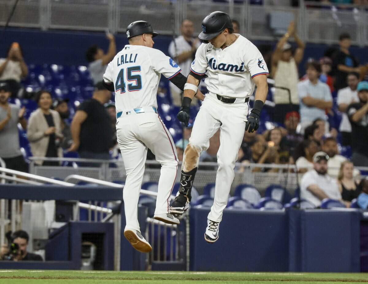 El jardinero de los Marlins Griffin Conine (der.) celebra con el coach de tercera base Blake Lalli tras pegar un jonrón en el tercer inning del partido ante los Rojos de Cincinnati, efectuado el 8 de abril de 2026 en Miami.