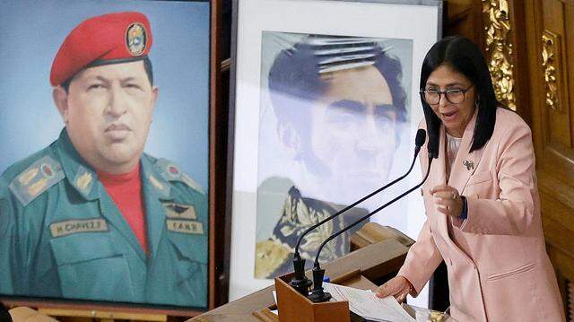 Venezuela's Vice President Delcy Rodriguez speaks past portraits of late Venezuelan President Hugo Chavez and the liberator Simon Bolivar during the presentation of the 2026 fiscal year budget at the National Congress in Caracas on December 4, 2025. The Venezuelan government presented its budget for 2026 on December 4, 2025, which, calculated in dollars, is 12% less than the budget approved for 2025, while denouncing "a Dantesque deployment" of US military forces in the Caribbean. (Photo by Pedro MATTEY / AFP via Getty Images)