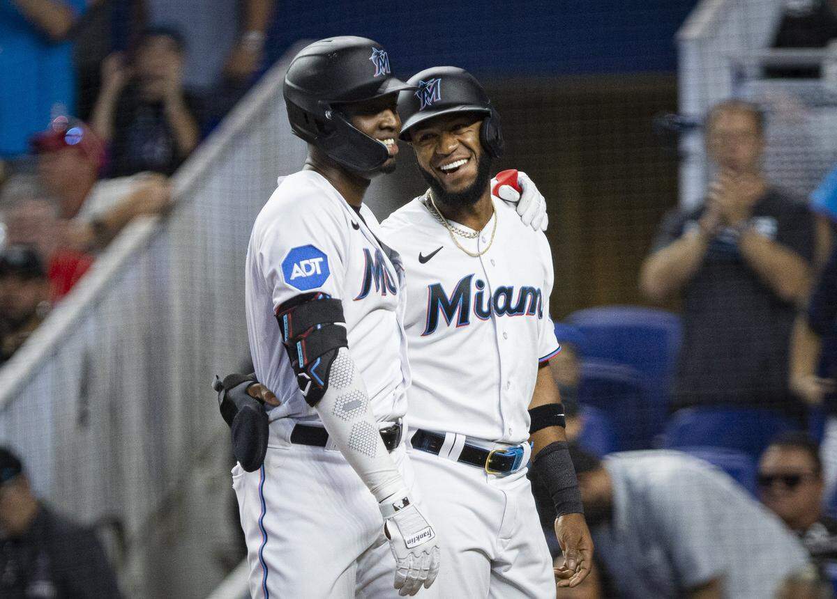 Los peloteros de los Marlins Jesús Sánchez (izq.) y Bryan De La Cruz sonríen luego de que el primero pegara un  jonrón en el primer inning del partido ante los Filis de Filadelfia, celebrado el 10 de julio de 2023 en Miami.