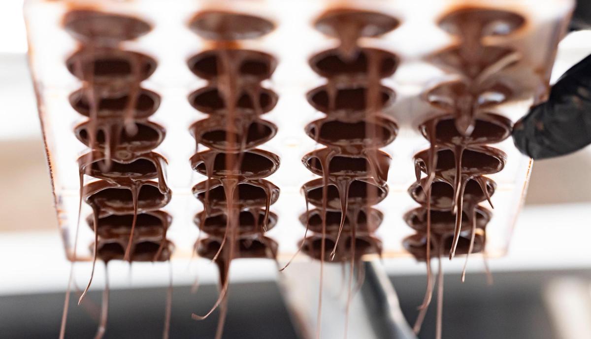 Carolina Quijano vacía un molde de bombón de chocolate en su nueva fábrica en Miami.