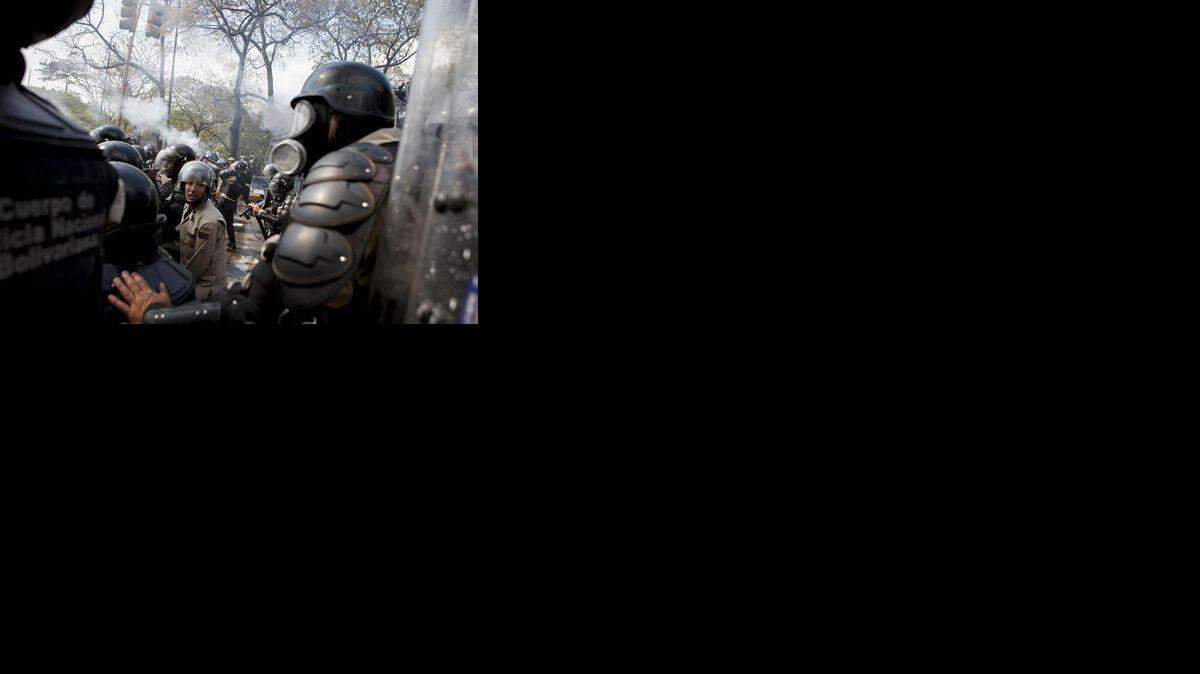Agentes de la Policía Nacional Bolivariana se enfrentan a manifestantes opositores en la Universidad Central de Venezuela (UCV) en Caracas, en marzo del 2014.