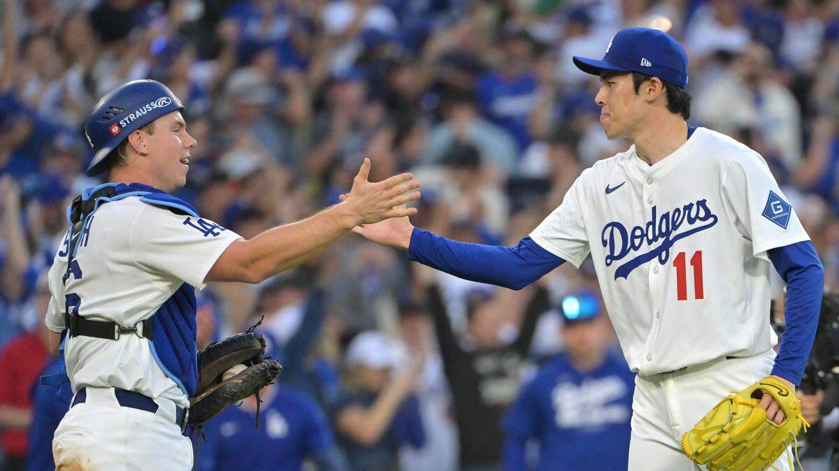 El relevista de los Dodgers Roki Sasaki (der.) celebra con el receptor Will Smith tras vencer a los Cerveceros en el cuarto partido de la Serie de Campeonato de la Liga Nacional, celebrado el 16 de octubre de 2025 en el Dodger Stadium.