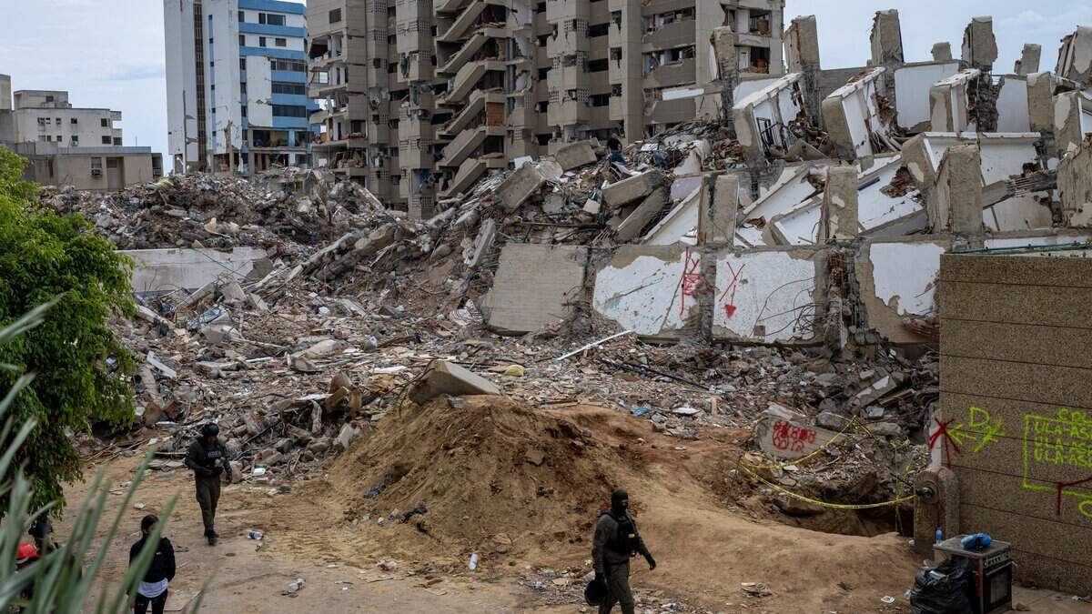 Members of the Strategic Operations Group (GOES) patrol a quake-hit area in Playa Grande neighbourhood, state of La Guaira, on July 3, 2026. The death toll from Venezuela's devastating twin earthquakes has risen to 2,645, with more than 12,600 injured and thousands mores reported still missing, according to new official figures. (Photo by Miguel MEDINA / AFP via Getty Images)