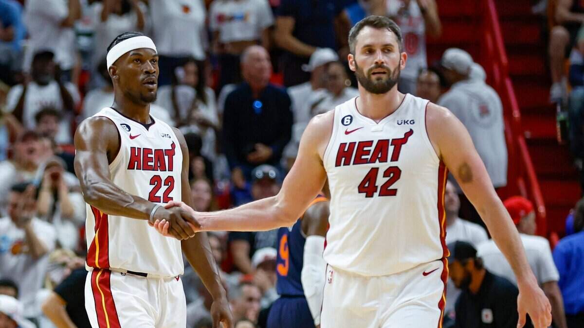 Los delanteros del Heat Kevin Love (42) y Jimmy Butler (22) se dan la mano en la cancha en el partido contra los New York Knicks en el primer cuarto durante el Juego 3 de las Semifinales de la Conferencia Este de la NBA en el Kaseya Center en Miami el sábado, mayo 6, 2023.