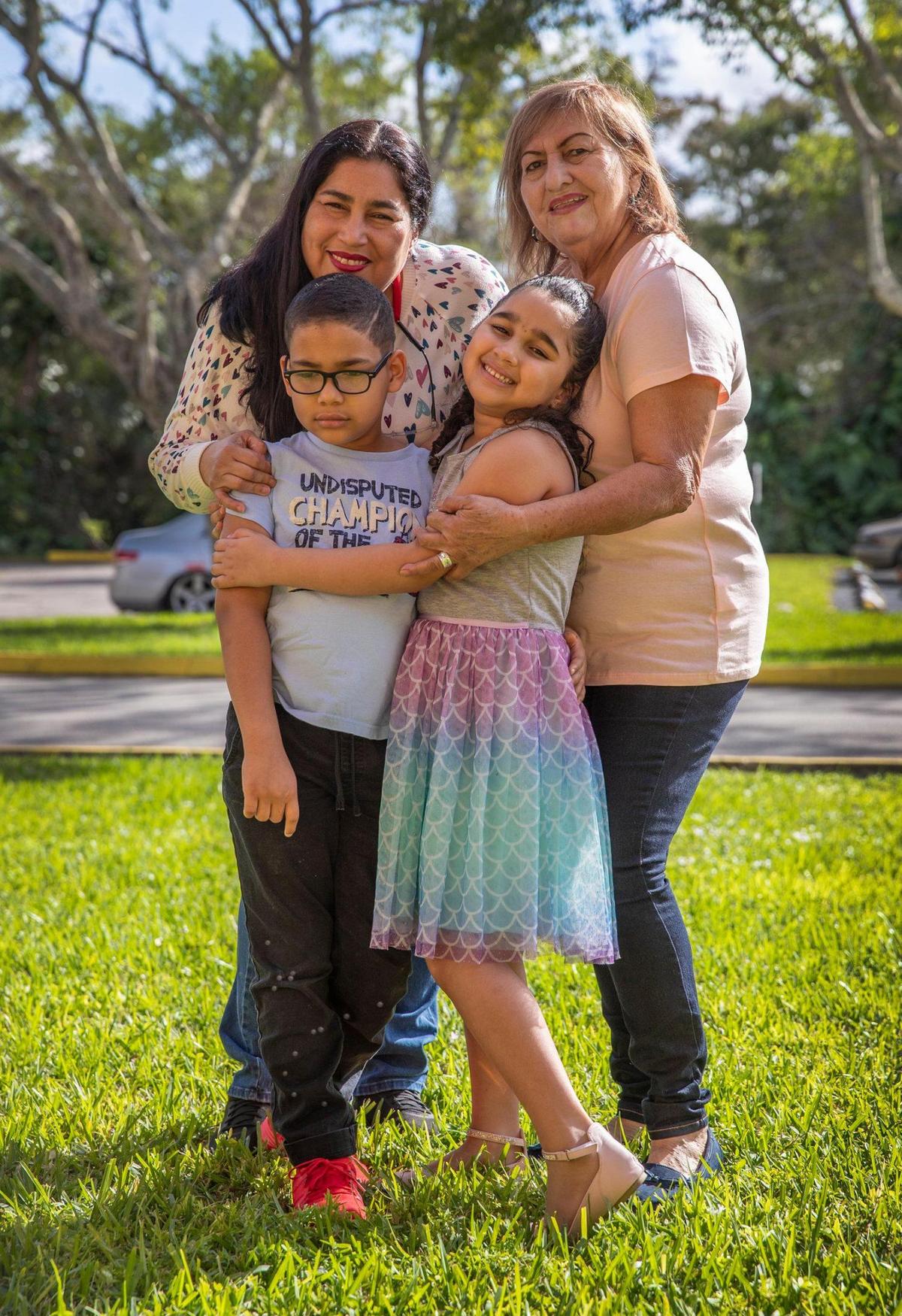 Rosana Ponte de Lara, left, with her children Francisco José, 8, and Paola, 6, and grandmother, Rosalba Ponte, in front of their Tamarac apartment. The Venezuelan family, including Francisco’s father (not shown) who arrived in Florida last year, dedicate most of their efforts to caring for Francisco, who has leukemia.