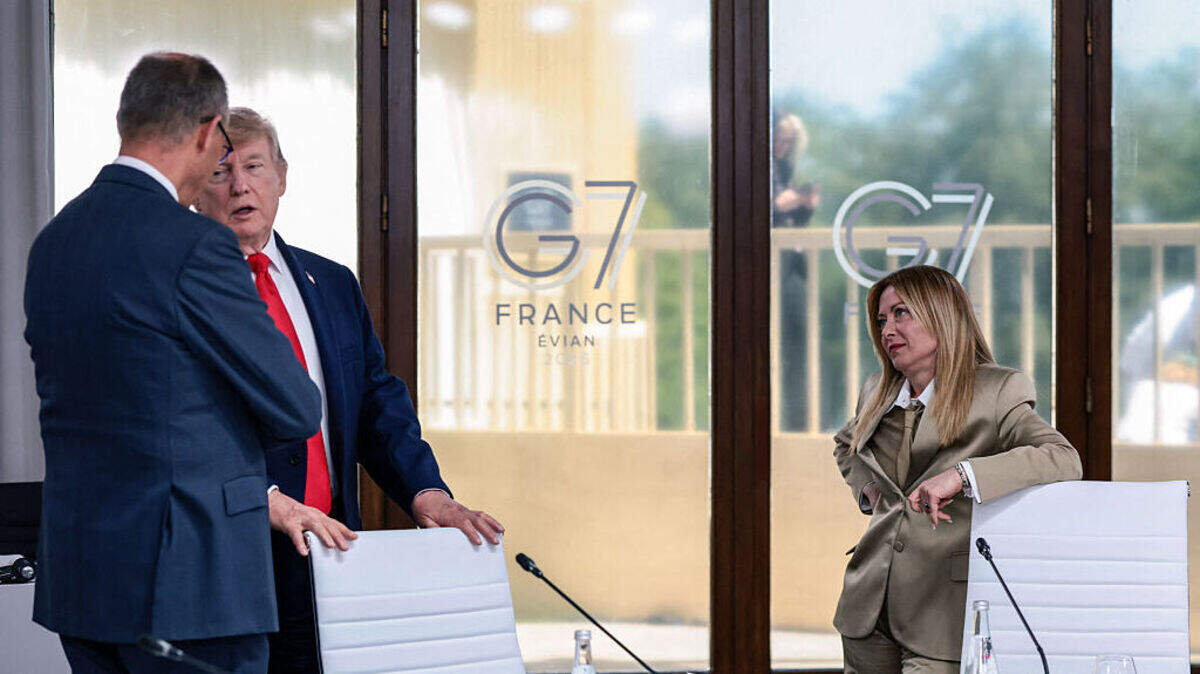 La primera ministra de Italia, Giorgia Meloni, observa la conversación entre el presidente de Estados Unidos, Donald Trump, y el canciller alemán, Friedrich Merz, durante un almuerzo de trabajo del G7, el 16 de junio de 2026 en Evián-les-Bains, Francia.