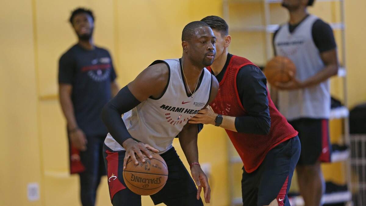 Dwyane Wade (izq.) trabaja con Chris Quinn, asistente del coach del Heat Erik Spoelstra, durante una práctica el miércoles 18 de abril de 2018 en la Arena American Airlines de Miami.