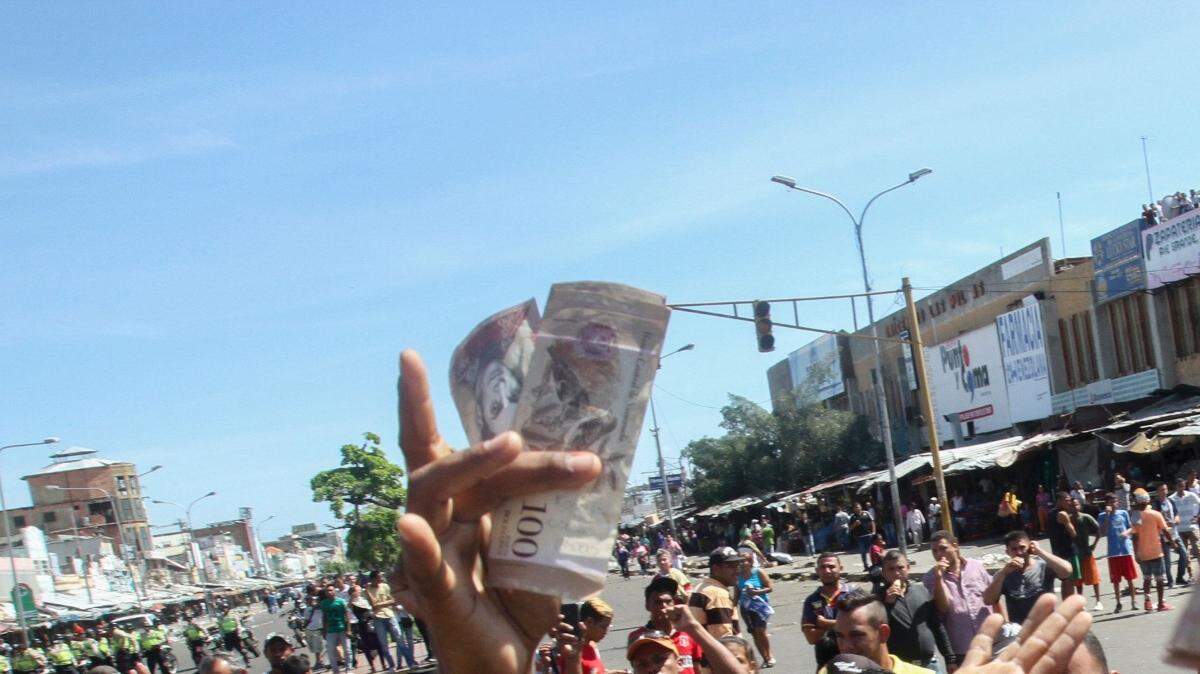 Cientos de personas protestas por la falta de efectivo en las afueras del Banco Central el viernes en el centro de Maracaibo, estado Zulia. 