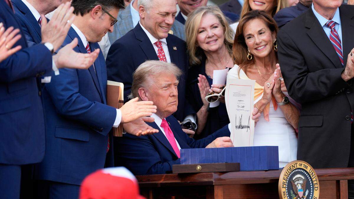 President Donald Trump holds up his signed signature bill of tax breaks and spending cuts at the White House in Washington, Friday, July 4, 2025.(Photo by Alex Brandon/Pool/Sipa USA)
