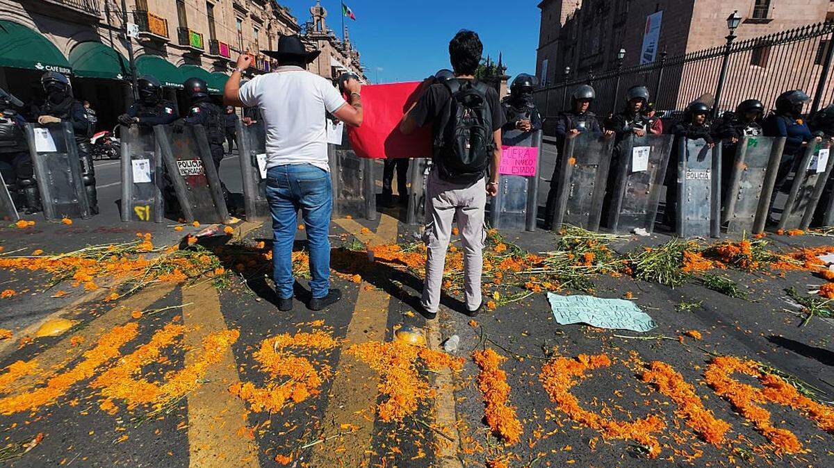 Protesters demonstrate against the assassination of Uruapan's mayor in front of police officers at the Government Palace in Morelia, Michoacan state, Mexico, on November 3, 2025. The Mexican government reported on November 2 that the mayor of Uruapan, Carlos Manzo, who was killed the previous night during a public event in the western state of Michoacan, had been under official protection since December last year. (Photo by Jordi LEBRIJA / AFP) (Photo by JORDI LEBRIJA/AFP via Getty Images)
