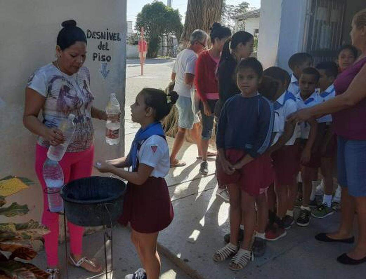 Maestras en Cuba le lavan las manos a los niños para prevenir el COVID-19