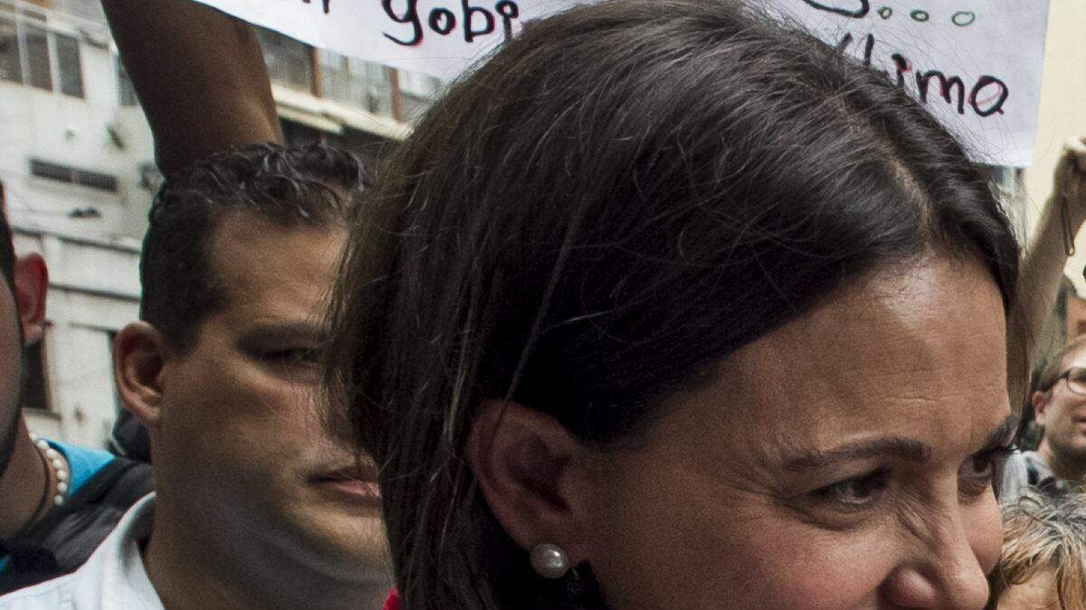 La ex diputada de la Asamblea Nacional (AN) venezolana María Corina Machado saluda a seguidores en las inmediaciones al Ministerio Público luego de retirarse del recinto el miércoles 3 de diciembre de 2014, en la ciudad de Caracas.