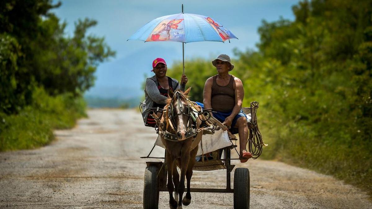 Foto de archivo que muestra dos personas viajando en una carreta de caballos por una calle de Viñales, en la provincia cubana de Pinar del Río, el 21 de julio de 2020. 