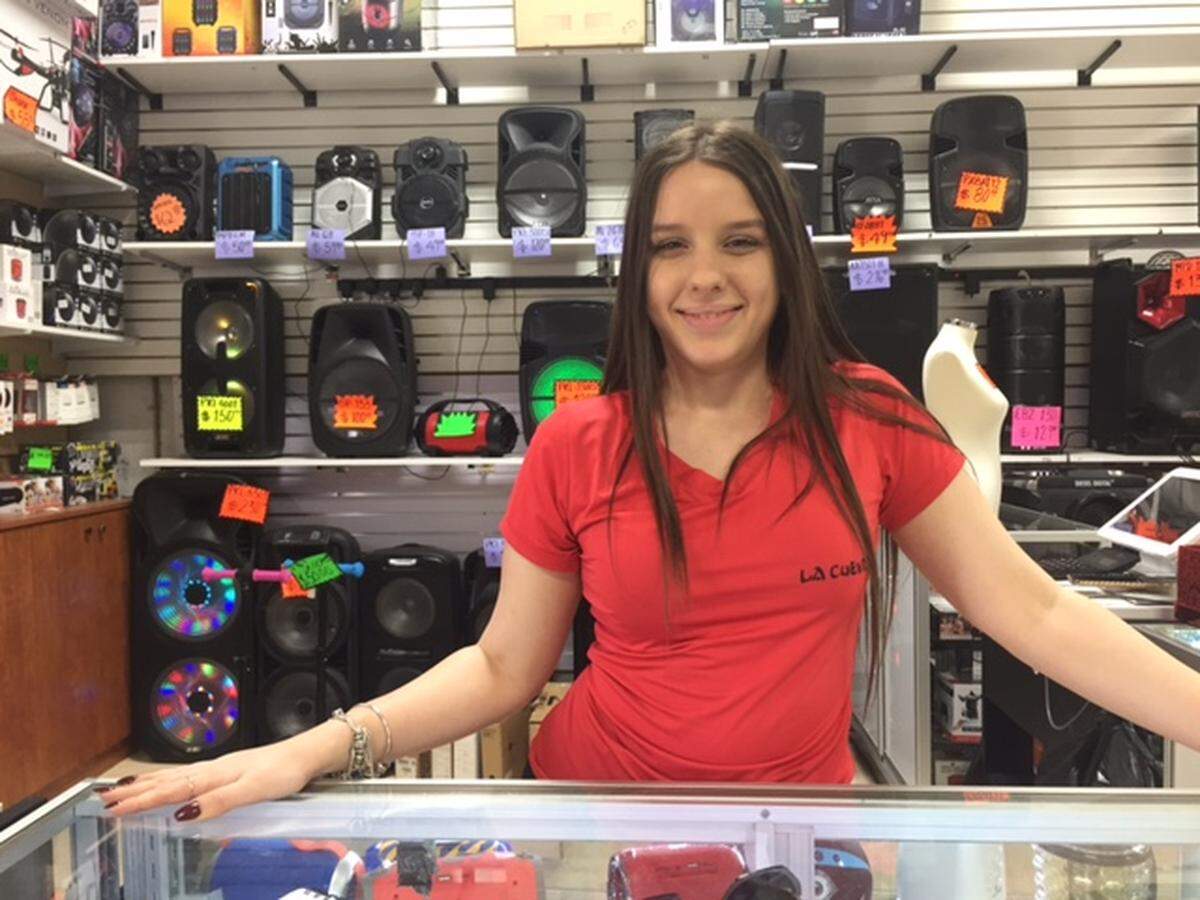 Rocío Acosta en el mostrador de equipos electrónicos en La Cuevita de San Miguel, un negocio de Miami Lakes que se caracteriza por los precios económicos.