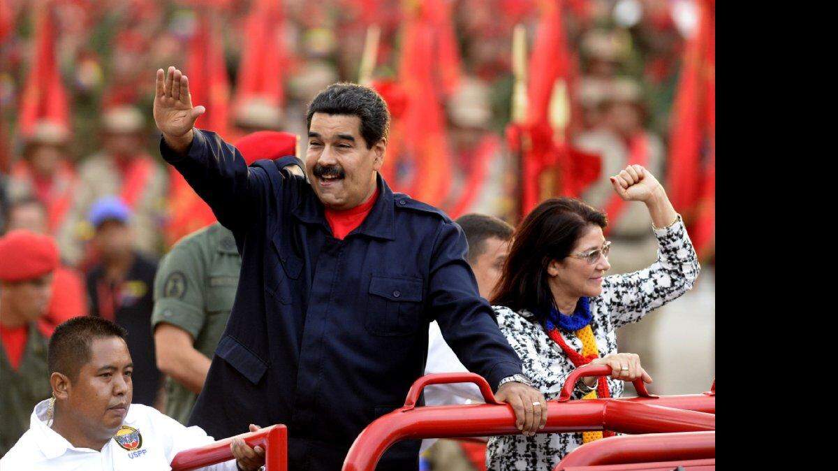 El presidente venezolano Nicolás Maduro y su esposa, Cilia Flores, saludan durante la celebración del quinto aniversario de la creación de las Milicias Bolivarianas el lunes, en Caracas. 