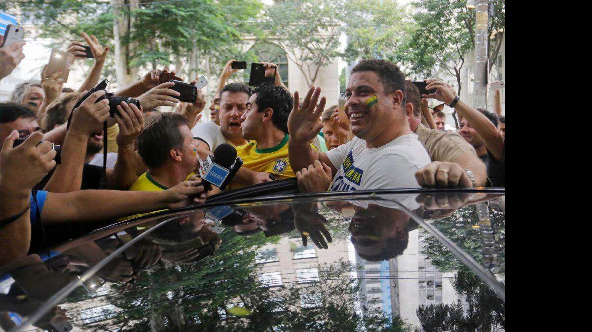 Ex futbolista Ronaldo de Brasil saluda a los manifestantes al entrar en un coche después de unirse a la protesta en Sao Paulo, Brasil, el domingo 15 de marzo de 2015. Los brasileños pacíficamente marcharon el domingo en ciudades de todo el país para exigir la destitución de la presidenta Dilma Rousseff, y de criticar la corrupción del gobierno.