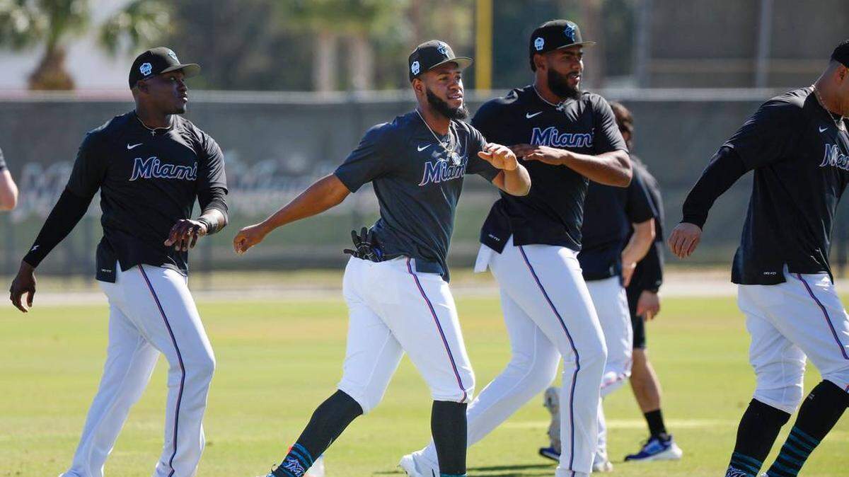 El jardinero de los Miami Marlins Bryan De La Cruz (centro) se estira antes de un entrenamiento de primavera en el Roger Dean Chevrolet Stadium en Jupiter, Florida, el martes 21 de febrero de 2023. Al Díaz adiaz@miamiherald.com
